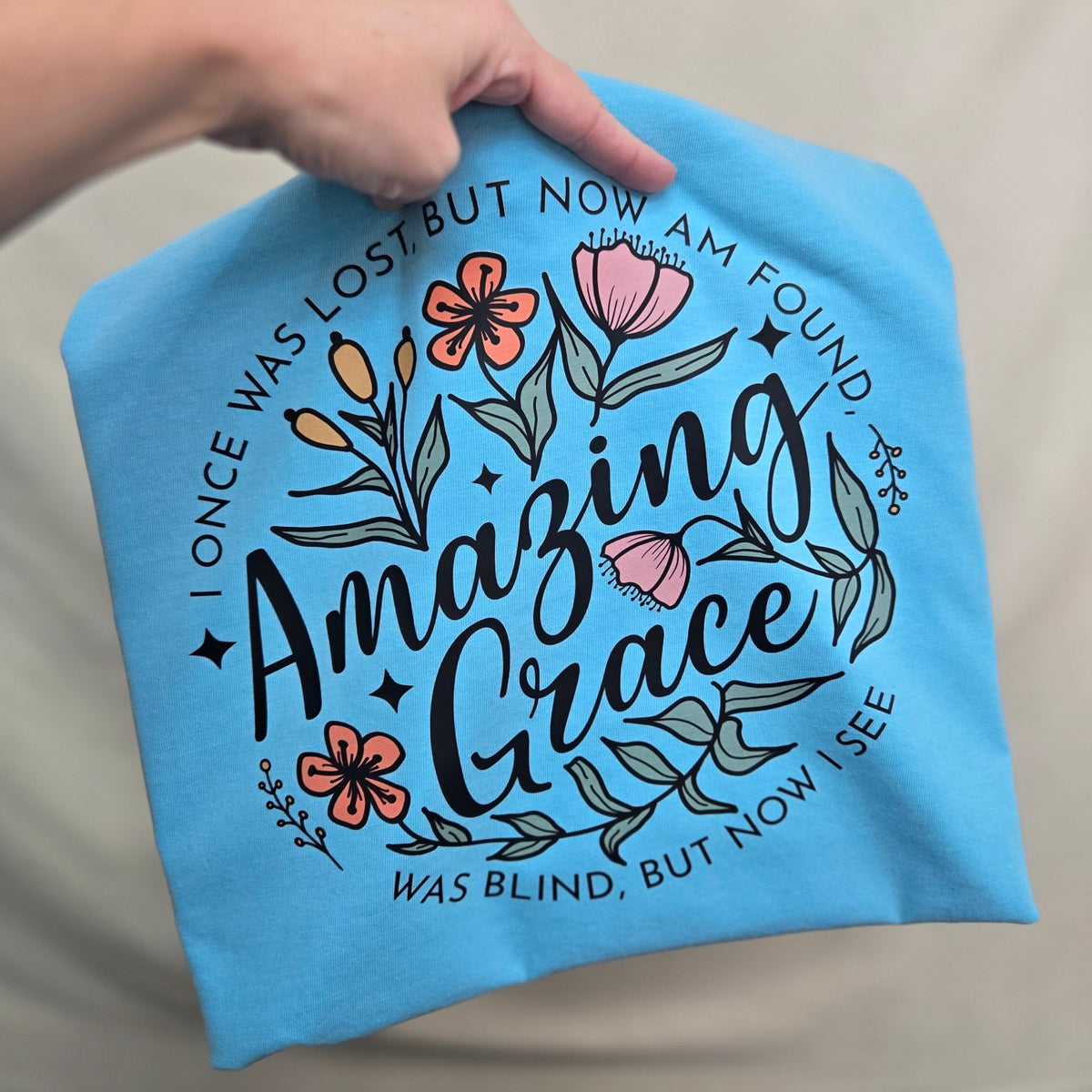 Comfort Colors short sleeve tee with floral Amazing Grace design and the words I once was lost but now am found, was blind but now I see