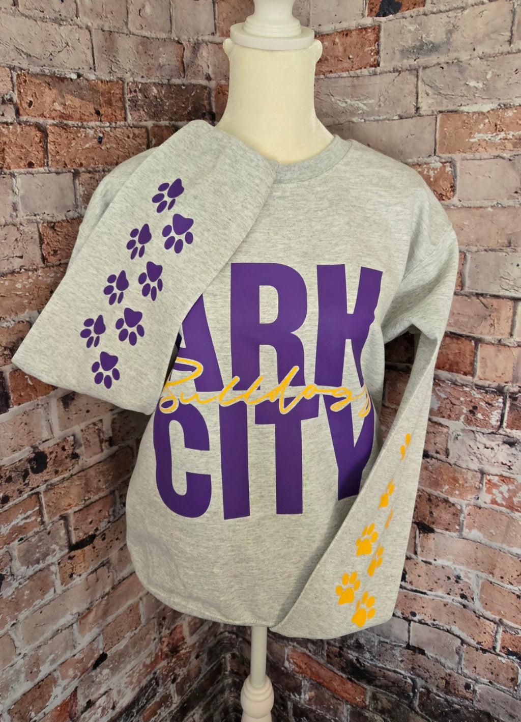 Heather gray Gildan crewneck with purple Ark City Bulldogs lettering and paw prints on sleeves