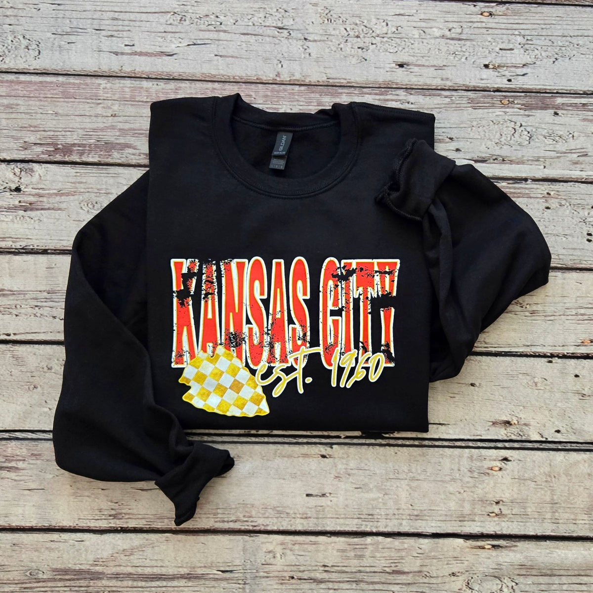 Black Gildan crewneck with distressed Kansas City lettering, Est. 1960 script, and yellow checkerboard state graphic